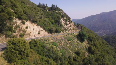 beautiful drone shot tracking a car driving through a mountain road in america