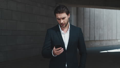 business man typing message on smartphone outdoors. man using cellphone