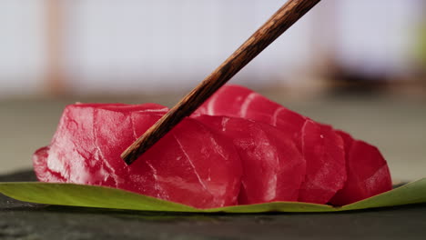 slices of tuna sashimi with chopsticks