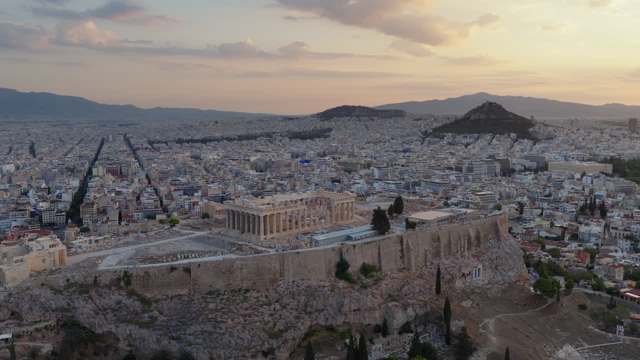 Morning light over the Acropolis and Parthenon in Athens, Greece, panoramic aerial orbit at sunrise, establish