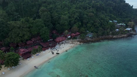 Morning-mood-Wonderful-aerial-view-flight-speed-ramp-of-a-tropical-island-with-a-long-wooden-pier-leading-to-a-floating-restaurant,-surrounded-by-turquoise-waters-and-lush-green-rainforest