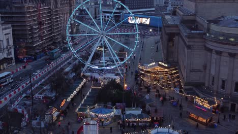 mercado de navidad de la ciudad de liverpool rueda de la fortuna en st georges square vista aérea pan derecho