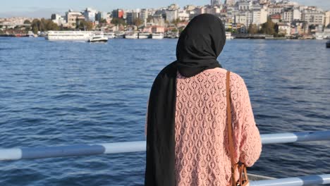 mujer en hijab viendo el paisaje urbano