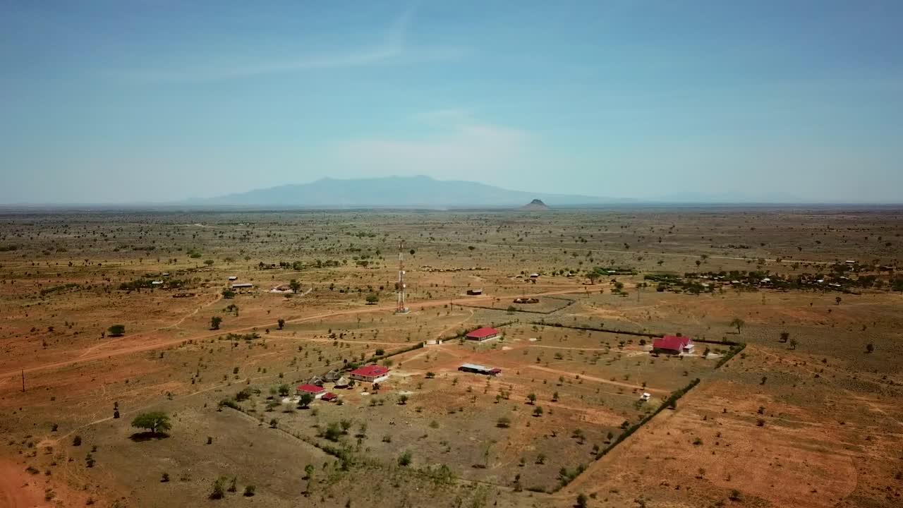 화창한 날, 아프리카 우간다에 있는 몇 개의 현대 주택과 통신 안테나의 정착지의 드론 뷰