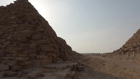 close up view beside base of the queen’s pyramids of giza with slow pan right