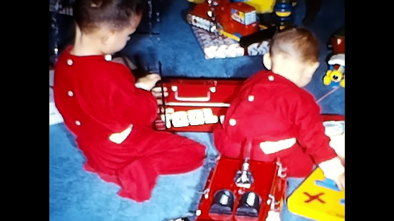 Baby Playing With Toys on the Floor. CIRCA USA - 1970s: A baby in the 1970s from the USA is joyfully playing with a variety of toys on the floor.