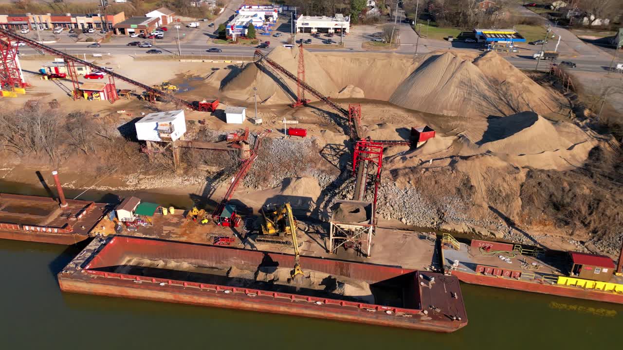 órbita aérea de la excavadora descargando arena de la barcaza en el río cumberland en clarksville, tennessee