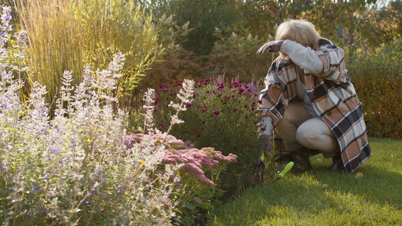 Elderly woman gardening in her backyard
