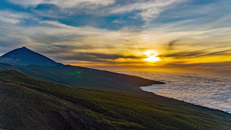 Sun-Setting-Over-A-Mountain-With-White-Fluffy-Clouds