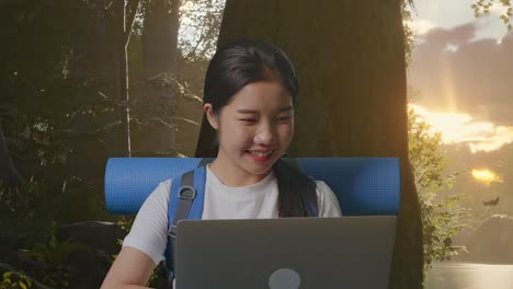 woman working on a laptop in a forest