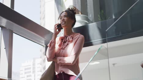 african american businesswoman talking on smartphone in creative office