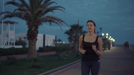 mujer corriendo en una playa por la noche