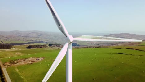 slow pullback shot of active wind turbine generating power. pull back slow from centre of turbine to reveal full turbine span