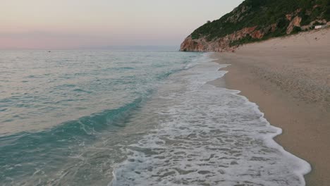 aerial view of beautiful milos beach of lefkada, ionian island, greece. sunset golden sunlight and pristine waves breaking the turquoise blue sea on the shore
