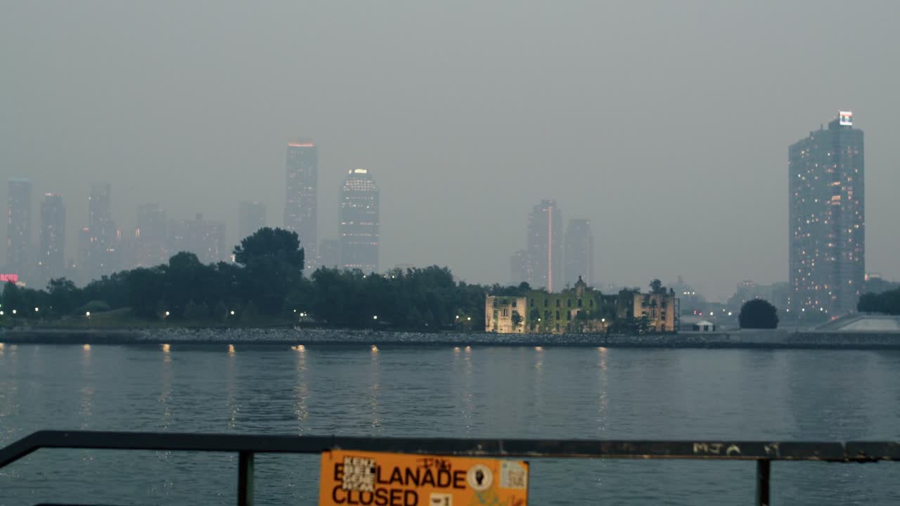 뉴욕 시는 산불의 연기로  ⁇ 여 있으며, 이스트 강 건너편에서 볼 수 있습니다. 카메라는 보행자 통로를 드러내기 위해 뒤로 물러납니다.