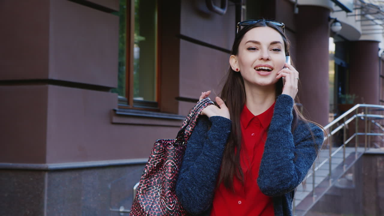 매력적인 갈색 머리는 휴대 전화 hd 비디오에 대해 이야기하는 도시를 산책