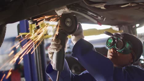 Video-of-african-american-female-car-mechanic-using-grinder