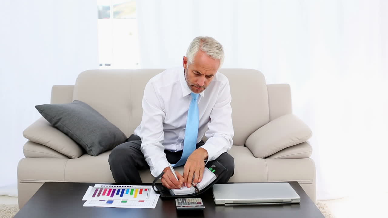 Empresário escrevendo em sua agenda e sorrindo para a câmera
