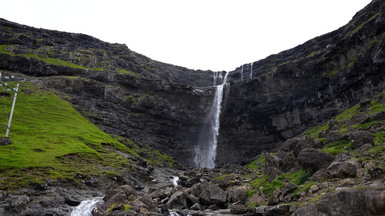 la inclinación hacia arriba revela una foto de la impresionante cascada de fossa en un día nublado, en las islas feroe
