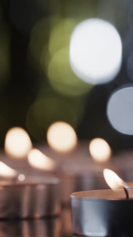 vertical video of lit tea candles and copy space on black background