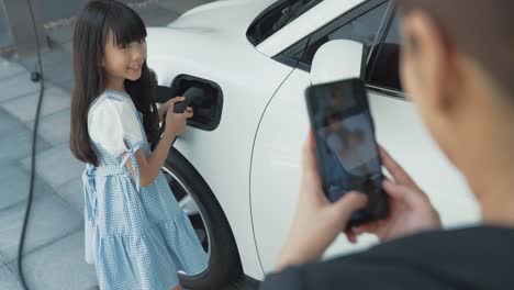 progressive lifestyle of mother and daughter with ev car and charging station.