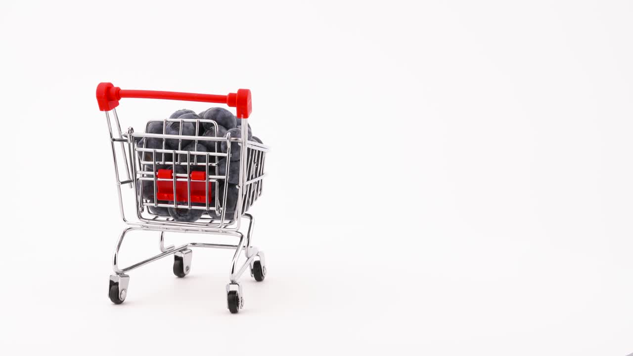 carrito de compras con bayas de arándano frescas moviéndose en el marco. aislado en el fondo blanco. primer plano. macro.