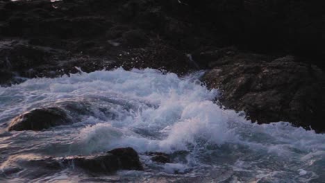 olas rompiendo en una costa rocosa al atardecer en cámara lenta