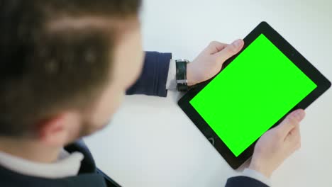 un hombre usando una tableta digital con una pantalla verde