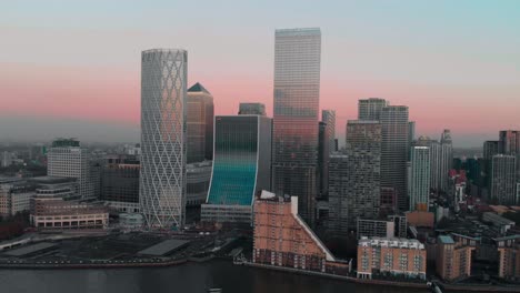 Toma-Aérea-De-Un-Dron-Giratorio-Cinematográfico-De-London-Canary-Wharf-Al-Atardecer