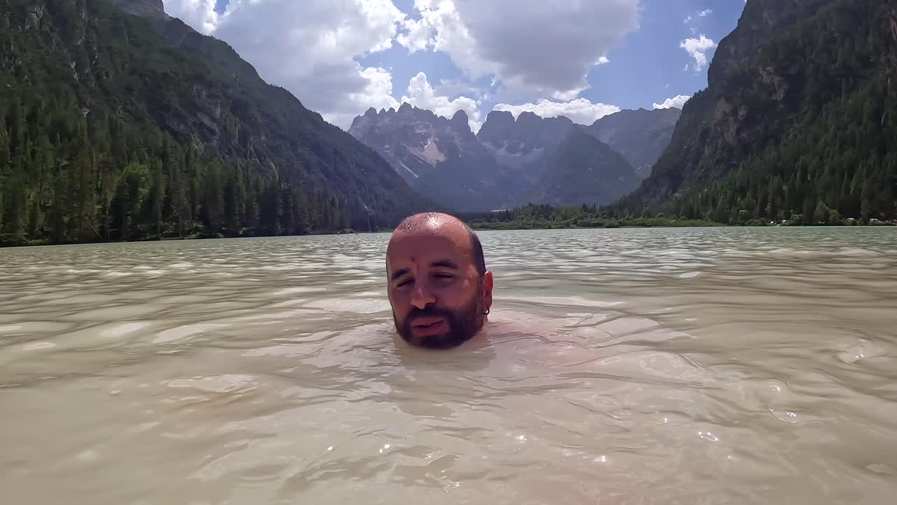 Man enjoying a refreshing swim in the dolomites' lago di landro during summer