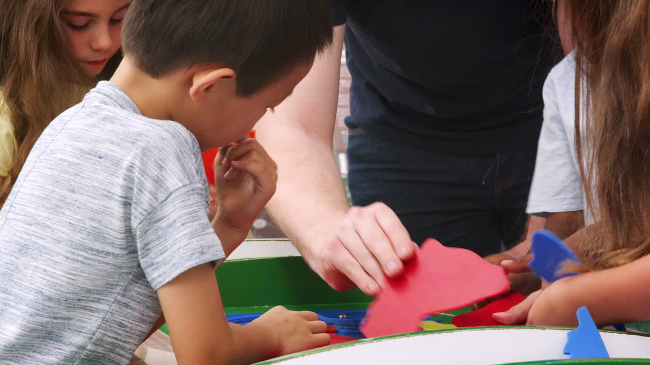 niños haciendo un rompecabezas con el maestro en el centro de ciencias, de cerca