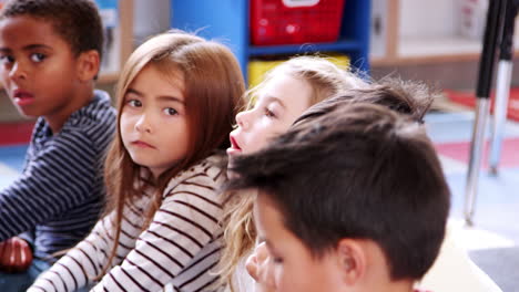 elementary schoolchildren listening and answering in class