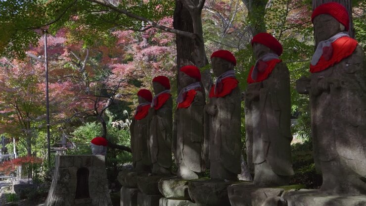 Magnifique travelling avant sur des statues de Jizo dans l’enceinte d’un temple japonais