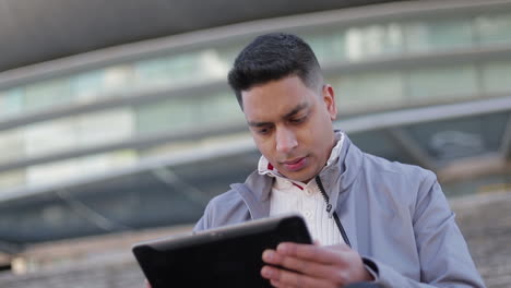 Joven-Enfocado-Usando-Tableta-Al-Aire-Libre