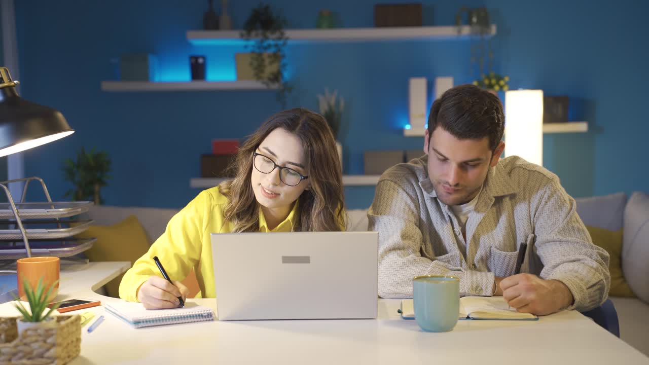 una pareja feliz trabajando juntos en una oficina en casa.