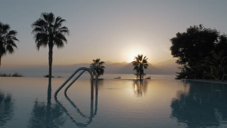 Una-Toma-De-Steadicam-De-Una-Piscina-Abierta-Y-Vacía-Al-Atardecer