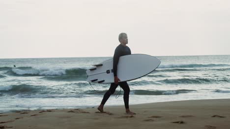 surfer walking on the beach with surfboard