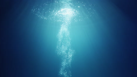 underwater sunlight beams shining from above coming through the deep crystal clear blue water causing a beautiful water lighting reflections curtain with air bubbles rising up to the surface