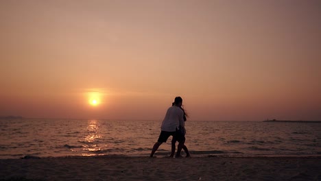 Silhouetten-Von-Männern-Und-Mädchen,-Die-Sich-An-Der-Küste-In-Zeitlupe-Amüsieren