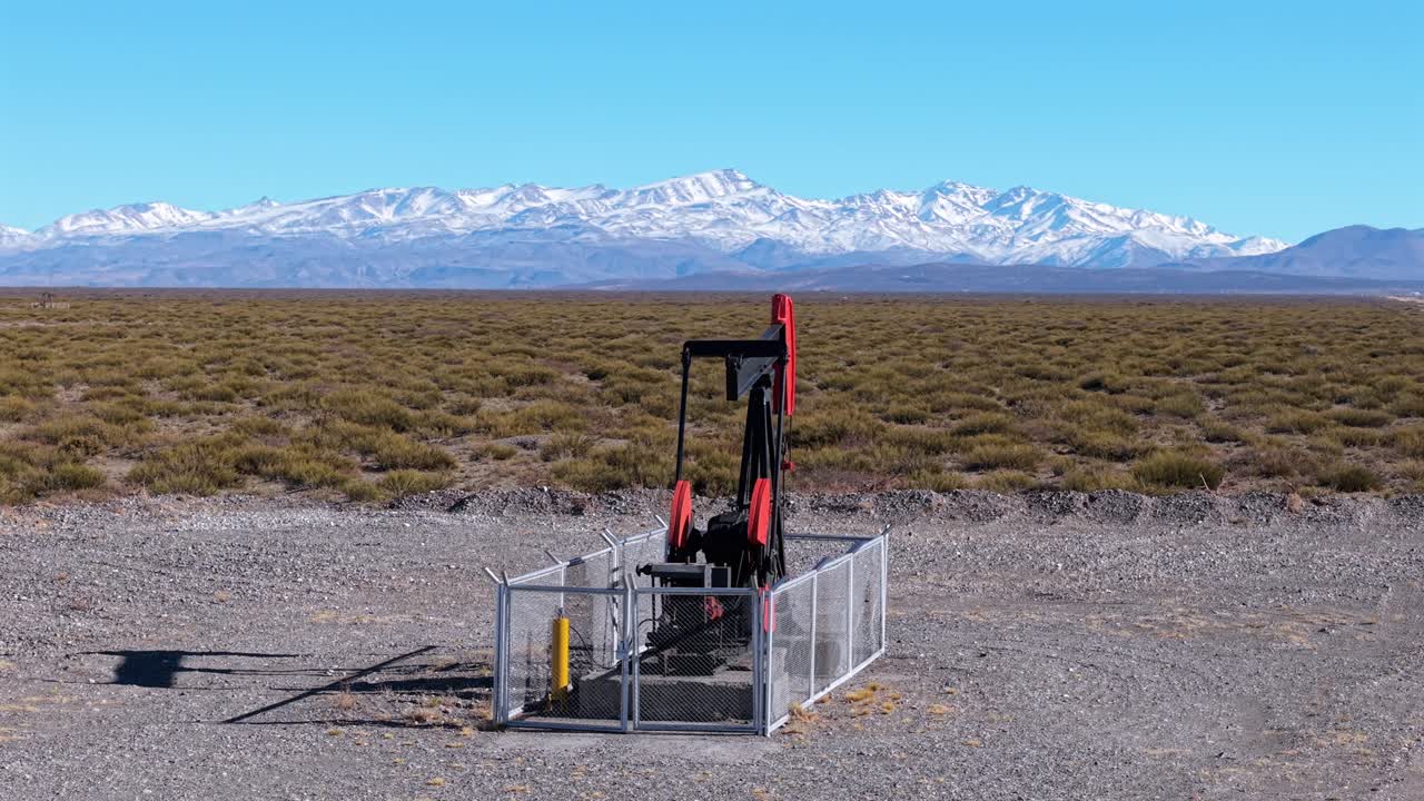 Oil pumpjack in Vaca Muerta field Patagonia Argentina with Andes mountains in background, energy and industry