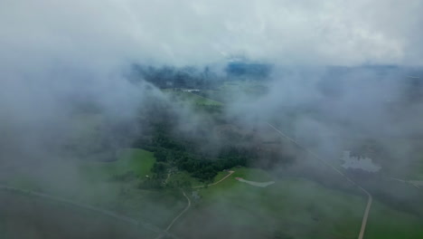 cinematic drone footage flying through clouds with a dramatic landscape below