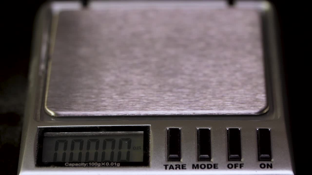 디지털 스케일에서 알약의 무게를 측정합니다.