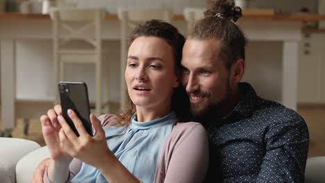 pareja lee sms en el teléfono inteligente con grandes noticias se siente muy feliz