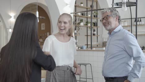 satisfied customers and manager standing in co-working space