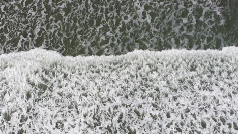 Aerial-bomb-shot-of-breaking-waves-at-low-tide-in-late-summer