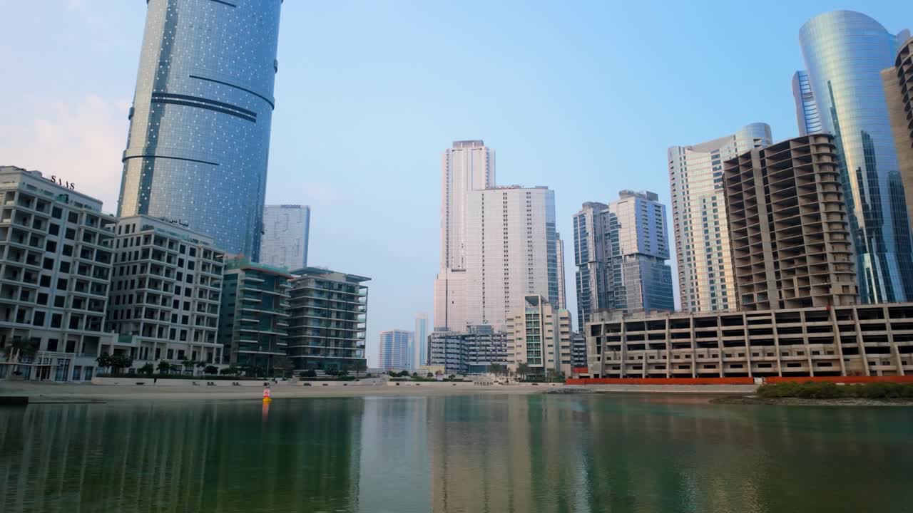 Al Reem Island showcasing stunning Abu Dhabi skyline and waterfront. Captures modern skyscrapers reflecting in tranquil lagoon under clear blue sky