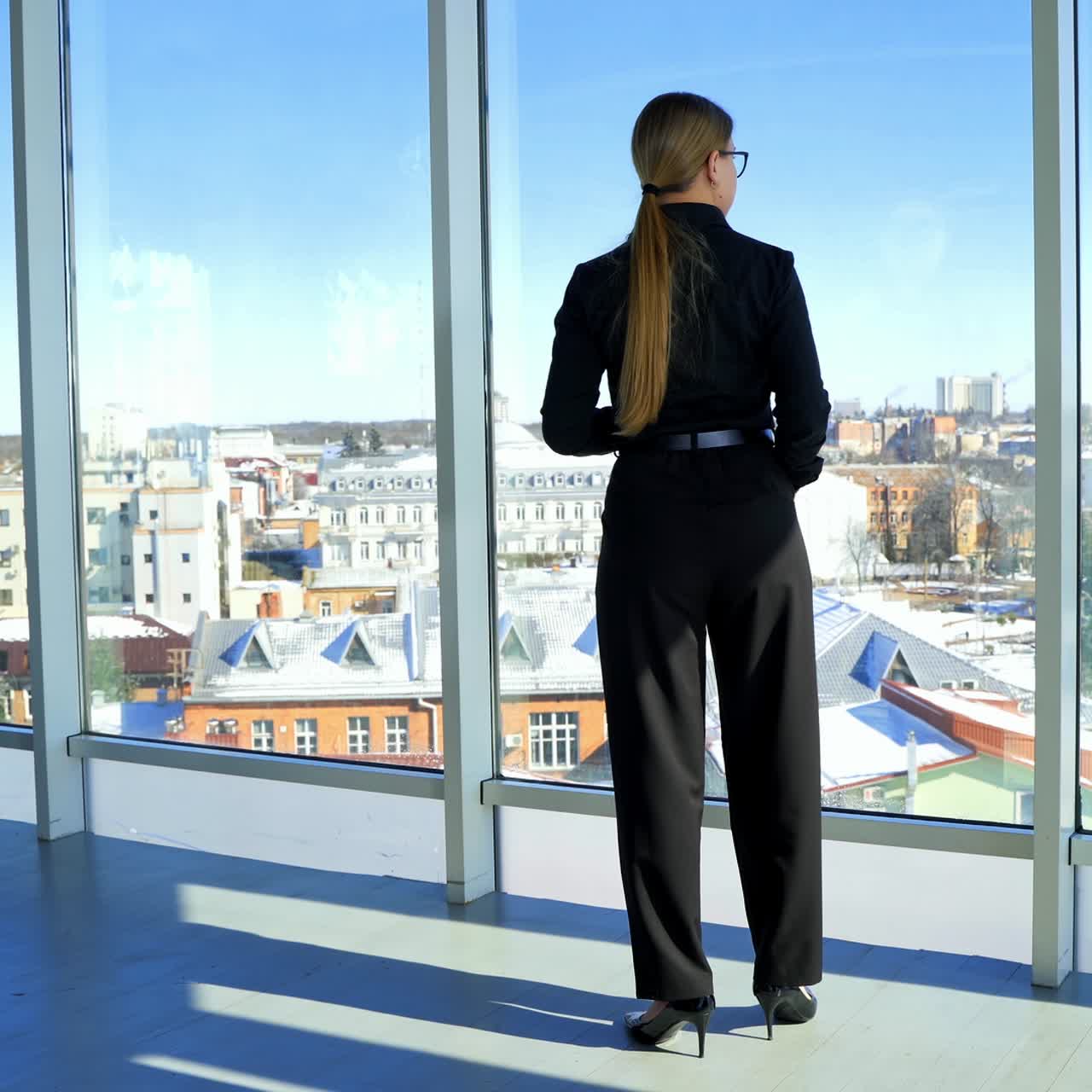 Beautiful business woman standing with coffee. Full-length portrait of an elegant woman near the office window. Panoramic window view with a city background