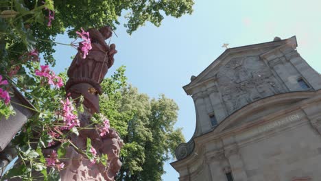 View-of-the-Maria-zu-den-Ketten-church-in-Zell-am-Harmersbach-on-a-summer's-day,-statue-of-the-Virgin-Mary-in-the-foreground