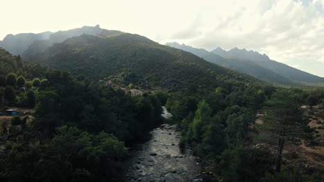 Langsamer-Flug-Zwischen-Den-Bäumen-Und-Einem-Fluss-Auf-Korsika-Folgend