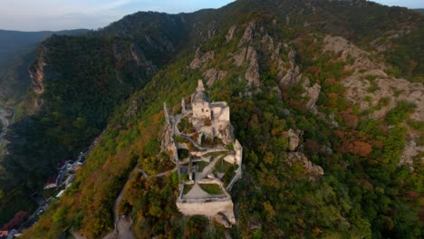 Impresionante-Toma-Aérea-De-Las-Ruinas-De-Dürnstein,-Ascendiendo-Hacia-Los-Pacíficos-Bosques-De-Wachau